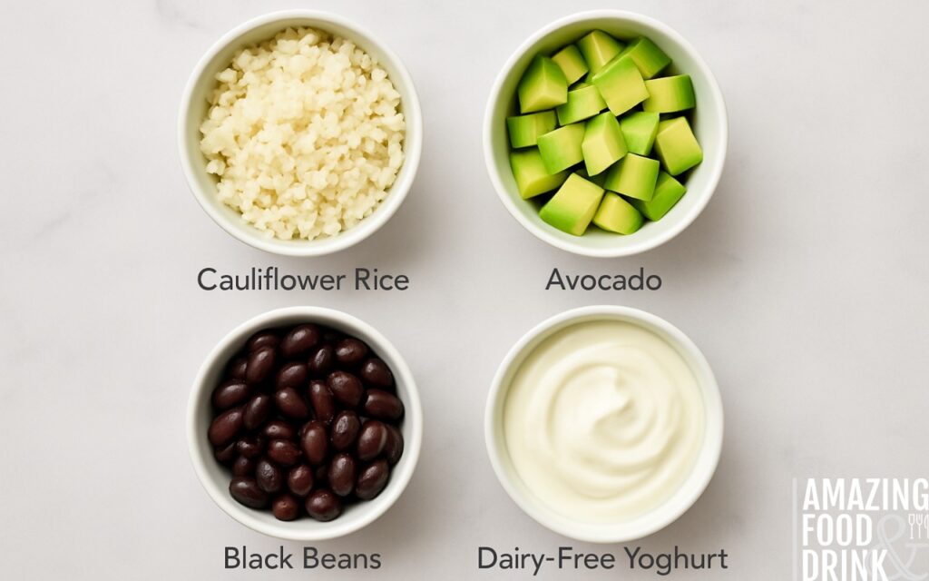 Four small bowls with healthy burrito ingredients: cauliflower rice, diced avocado, black beans, and dairy-free yoghurt on marble surface for nutritious meal alternatives