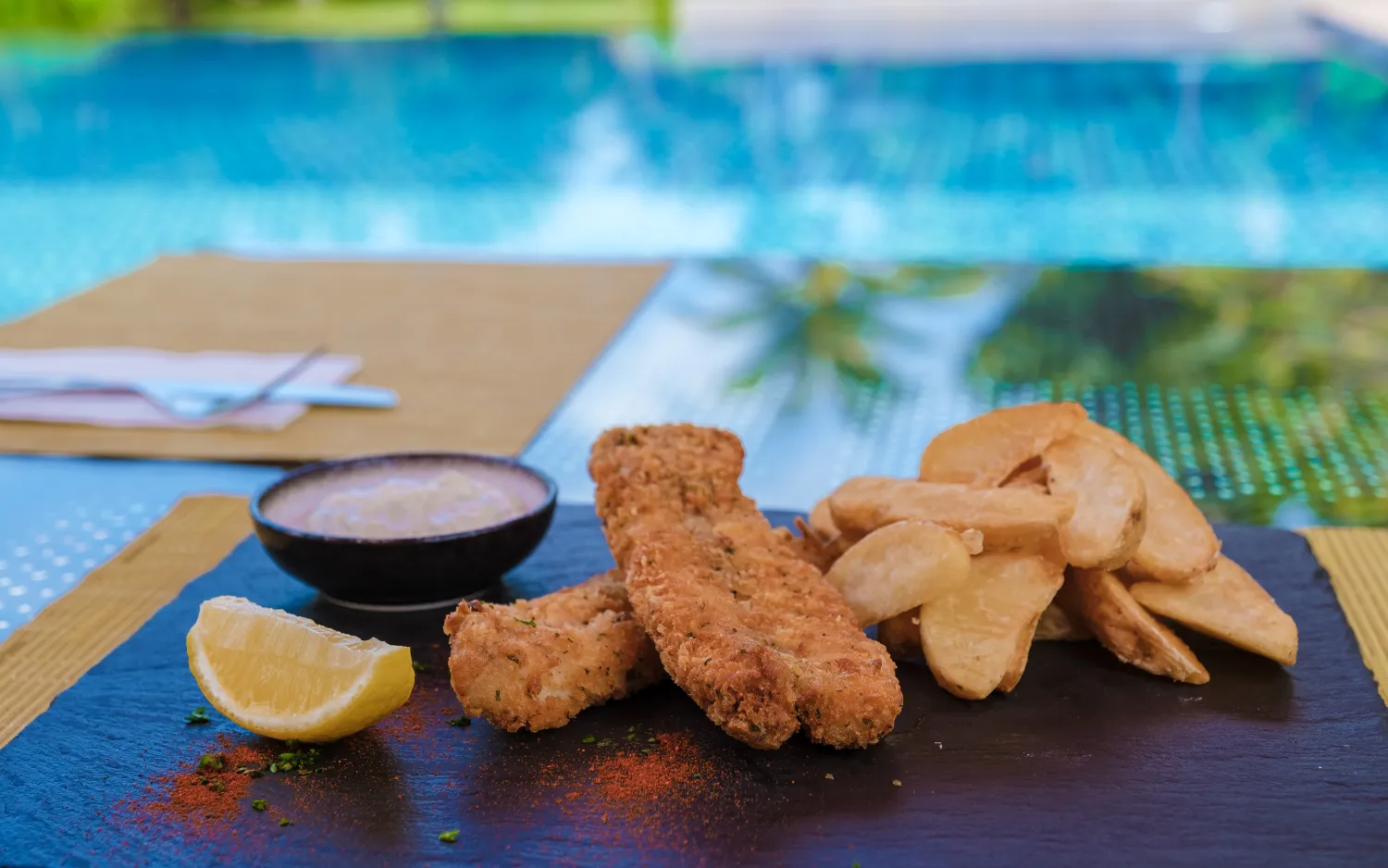 48799250 fish and chips on a plate isolated by the pool