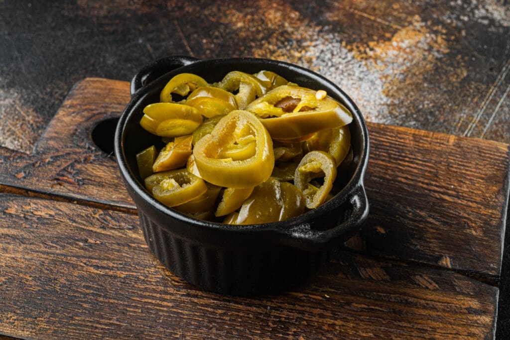 Pickled Or Canned Jalapeno Peppers On Old Dark Rustic Background