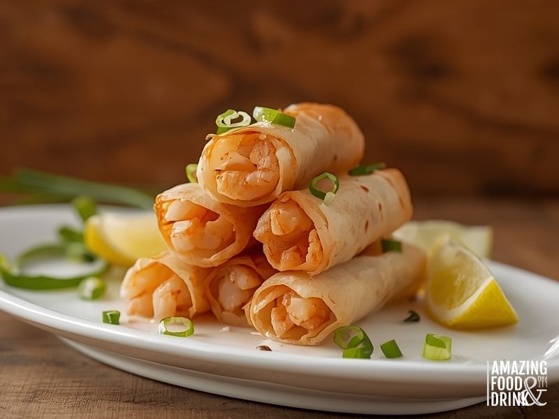 Prawn and ginger egg rolls showing pink prawn filling with lime wedges